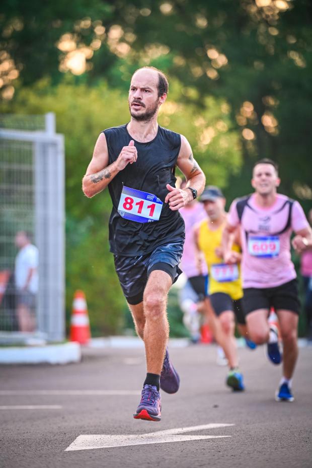 Corredor da Búfalos Team na reta final de prova de rua ao anoitecer