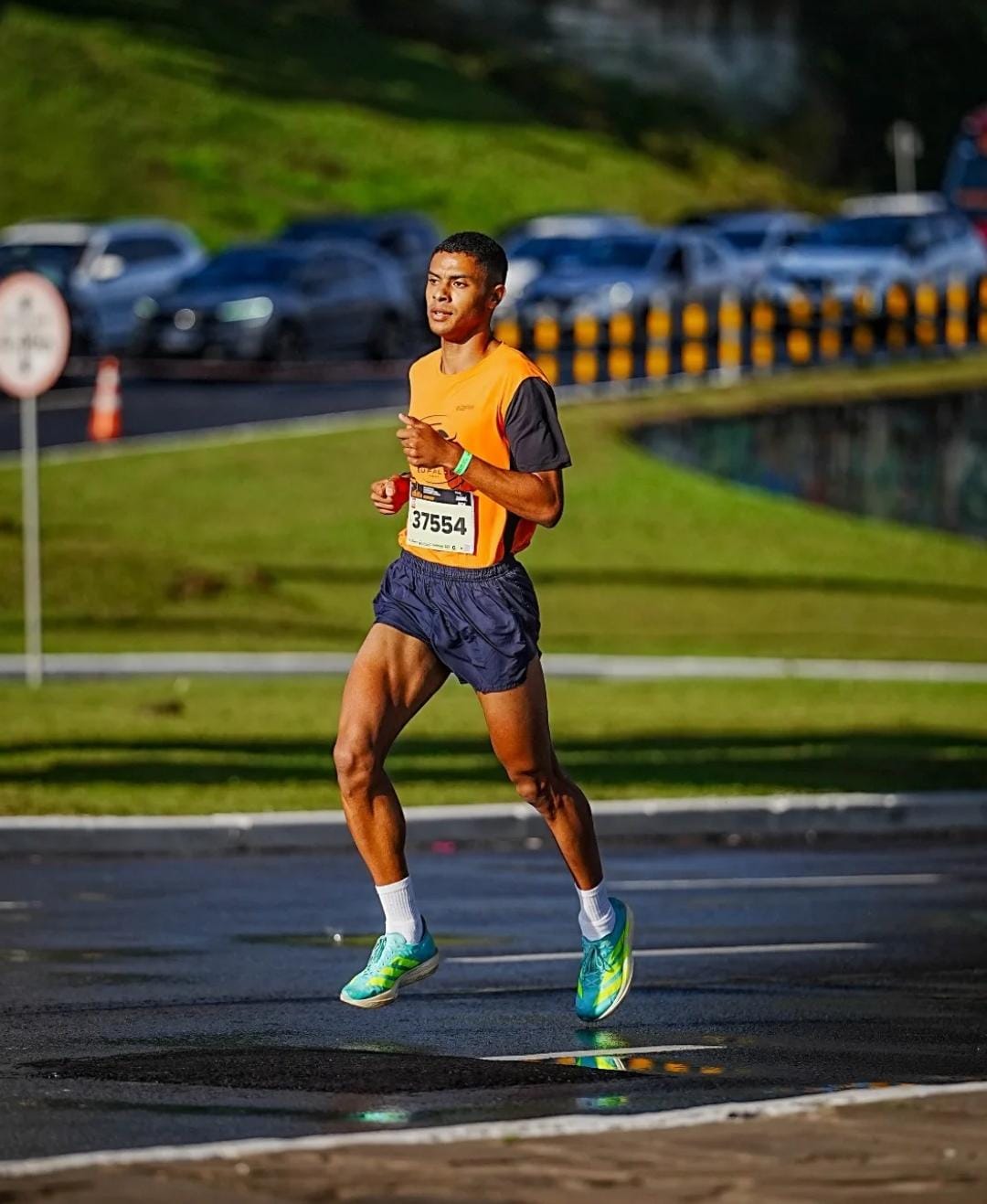 Atleta da Búfalos Team correndo em prova de rua com regata laranja