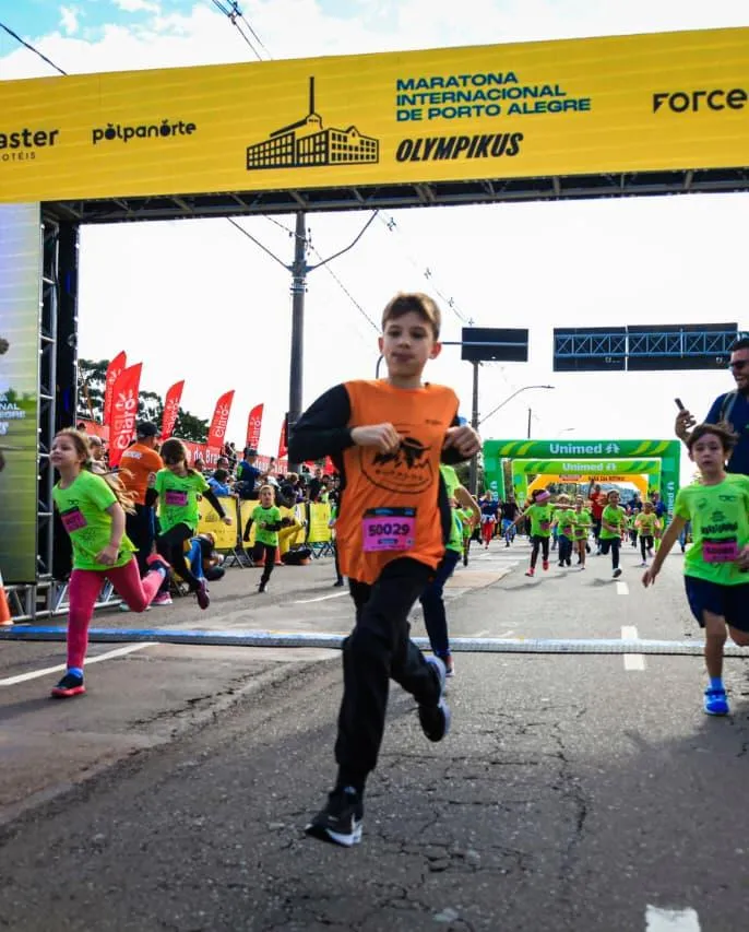Criança da Búfalos Team cruzando o pórtico da corrida kids da Maratona de Porto Alegre