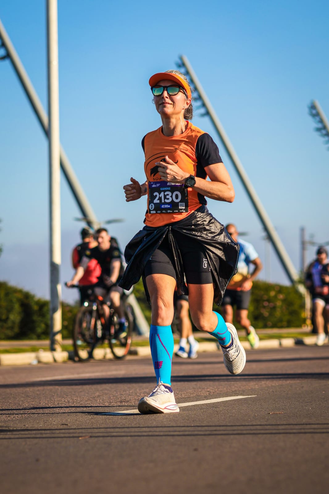 Aluna da Búfalos Team correndo a maratona com meias de compressão azuis