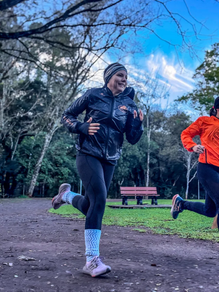 Aluna da Búfalos Team sorrindo enquanto corre no parque