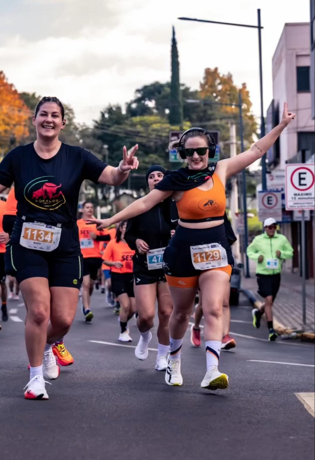 Duas alunas da Búfalos Team comemorando durante corrida de rua