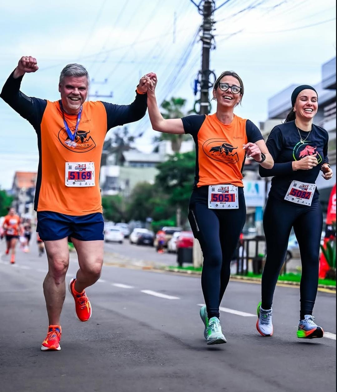 Alunos da Búfalos Team celebrando de mãos dadas na chegada da prova